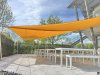 Ein großes aufrollbares gelbes Sonnensegel über einer Terasse mit vielen Sitzplätzen an Tischen bietet einen schattigen Platz | Lisori Sonnensegel