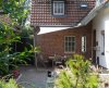 Dreieckiges beiges Sonnensegel befestigt an 2 Aufhängepunkten an der Hausfassade sowie 1 Segelmast von Lisori über der Terasse eines Einfamilienhauses | Lisori Sonnensegel