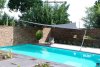 Graues Sonnensegel an und über einem Teil des Pools in einem modernen Garten | Lisori Sonnensegel