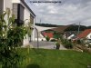 Ein großes cremefarbenes Sonnensegel von Lisori spendet Schatten auf dem Rasen vor einem weißen Haus. Die Stangen und Halterungen sind aus hochwertigem V2 Edelstahl. Ein cooler Ort zum Abhängen!